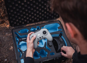 Une personne retire la radiocommande de la valise pour drone B&W International PP 326 avec une mousse adaptée pour transporter le drone et ses accessoires en toute sécurité.