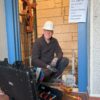 Servicetechniker mit Sicherheitshelm arbeitet an einem Aufzug, Werkzeugkoffer von B&W International steht geöffnet vor ihm.