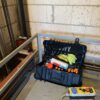 B&W International toolbox filled with tools, spray cans and a rag, ready for use on a construction site.